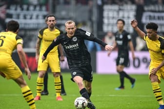 Frankfurts Sebastian Rode (M) versucht mit dem Ball zwischen den Dortmundern Thomas Delaney (l) und Jadon Sancho hinduch zu kommen.
