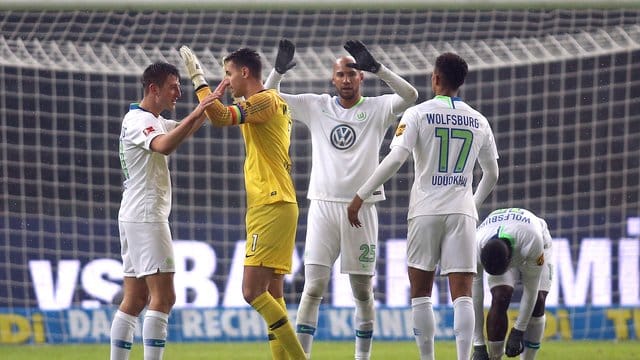 Die Wolfsburger Robin Knoche (l-r), Torwart Koen Casteels, John Anthony Brooks und Felix Uduokhai feiern nach Spielende. Die Wolfsburger Robin Knoche (l-r), Torwart Koen Casteels, John Anthony Brooks und Felix Uduokhai feiern nach Spielende.