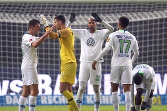 Die Wolfsburger Robin Knoche (l-r), Torwart Koen Casteels, John Anthony Brooks und Felix Uduokhai feiern nach Spielende.
