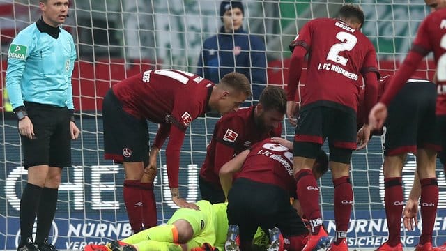 Der Nürnberger Torwart Christian Mathenia (M) liegt verletzt nach einem Zusammenstoß mit einem anderen Spieler auf dem Rasen. Der Nürnberger Torwart Christian Mathenia (M) liegt verletzt nach einem Zusammenstoß mit einem anderen Spieler auf dem Rasen.