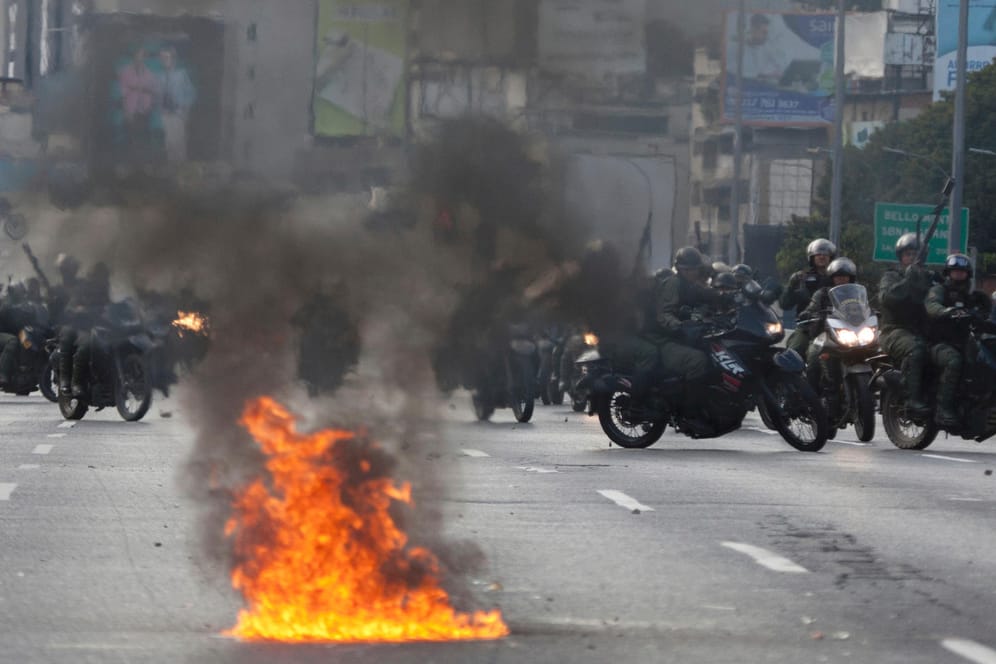 Mitglieder der venezolanischen Nationalgarde rücken auf Motorrädern gegen Oppositionelle vor: Machthaber Maduro droht im eskalierenden Konflikt in dem Land mit einem Bürgerkrieg.