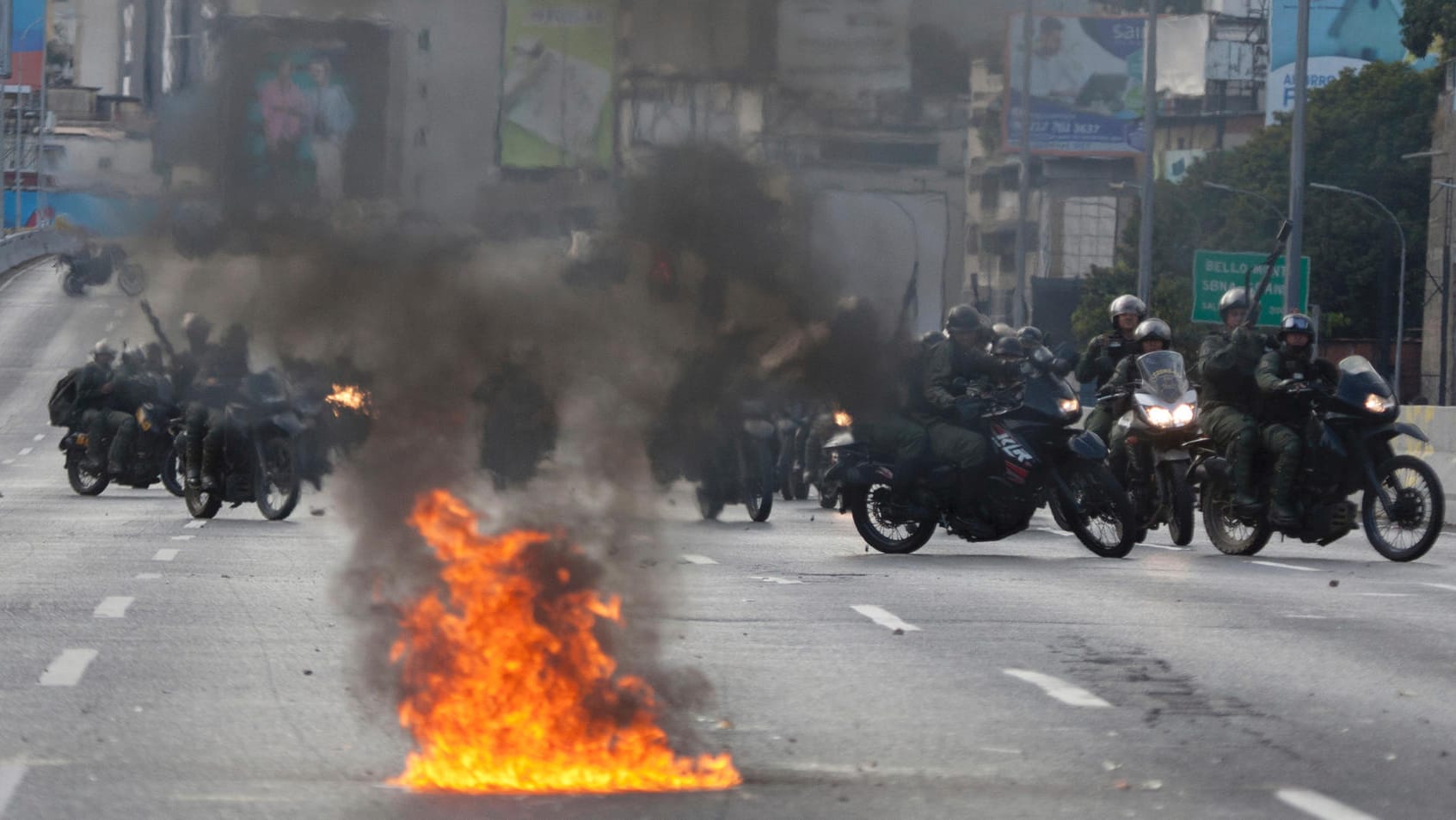 Mitglieder der venezolanischen Nationalgarde rücken auf Motorrädern gegen Oppositionelle vor: Machthaber Maduro droht im eskalierenden Konflikt in dem Land mit einem Bürgerkrieg.