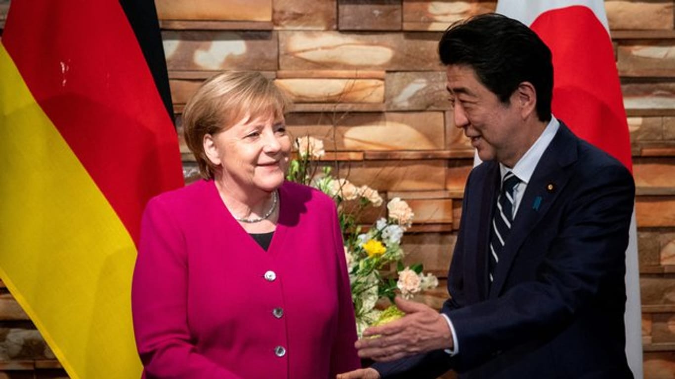Angela Merkel wird von Shinzo Abe begrüßt.