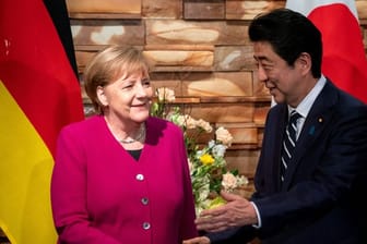 Angela Merkel wird von Shinzo Abe begrüßt.