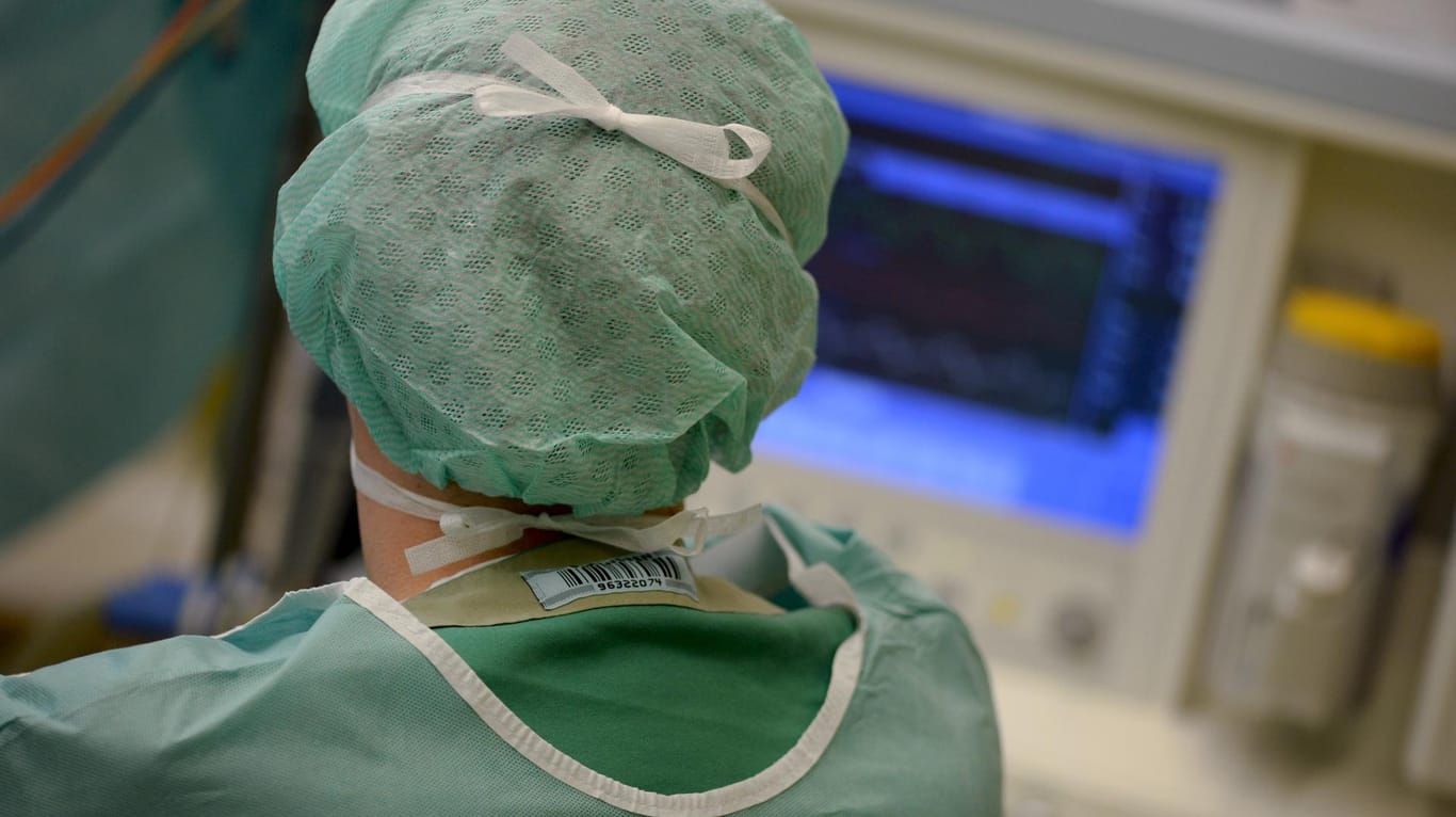Ein Mediziner schaut in einer Klinik während einer Operation auf einen Überwachungs-Monitor: IT unterstützt Ärzte in ihrem Berufsalltag. (Archivbild)