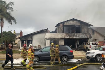 Feuerwehrleute im Einsatz: Beim Absturz eines Kleinflugzeugs auf ein Einfamilienhaus im US-Bundesstaat Kalifornien sind fünf Menschen getötet worden.