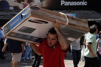 Ein Mann trägt einen LCD-Fernseher auf der Schulter: In den USA gehört die Verwertung von Nutzerdaten zum Geschäft mit "smarten" Fernsehern.
