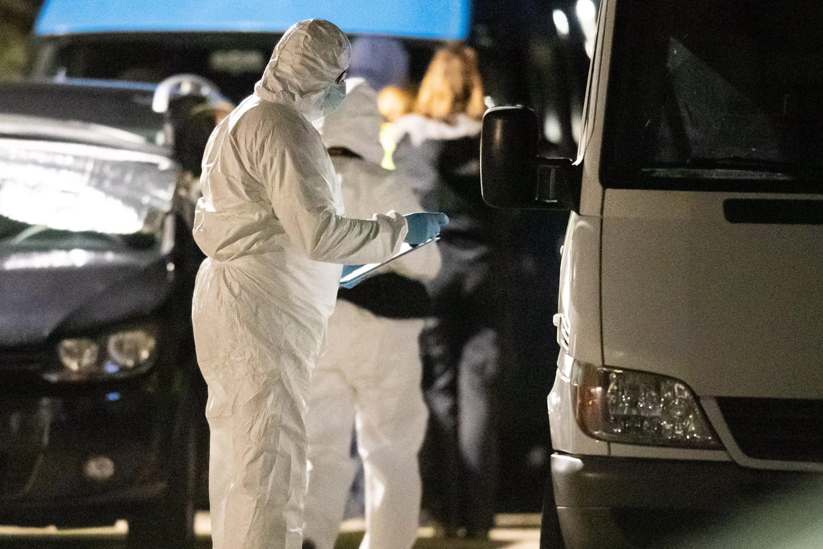 Ein Beamter der Spurensicherung steht während eines Polizeieinsatzes vor einem Auto: Noch ist unklar, weshalb der Mann verstarb.