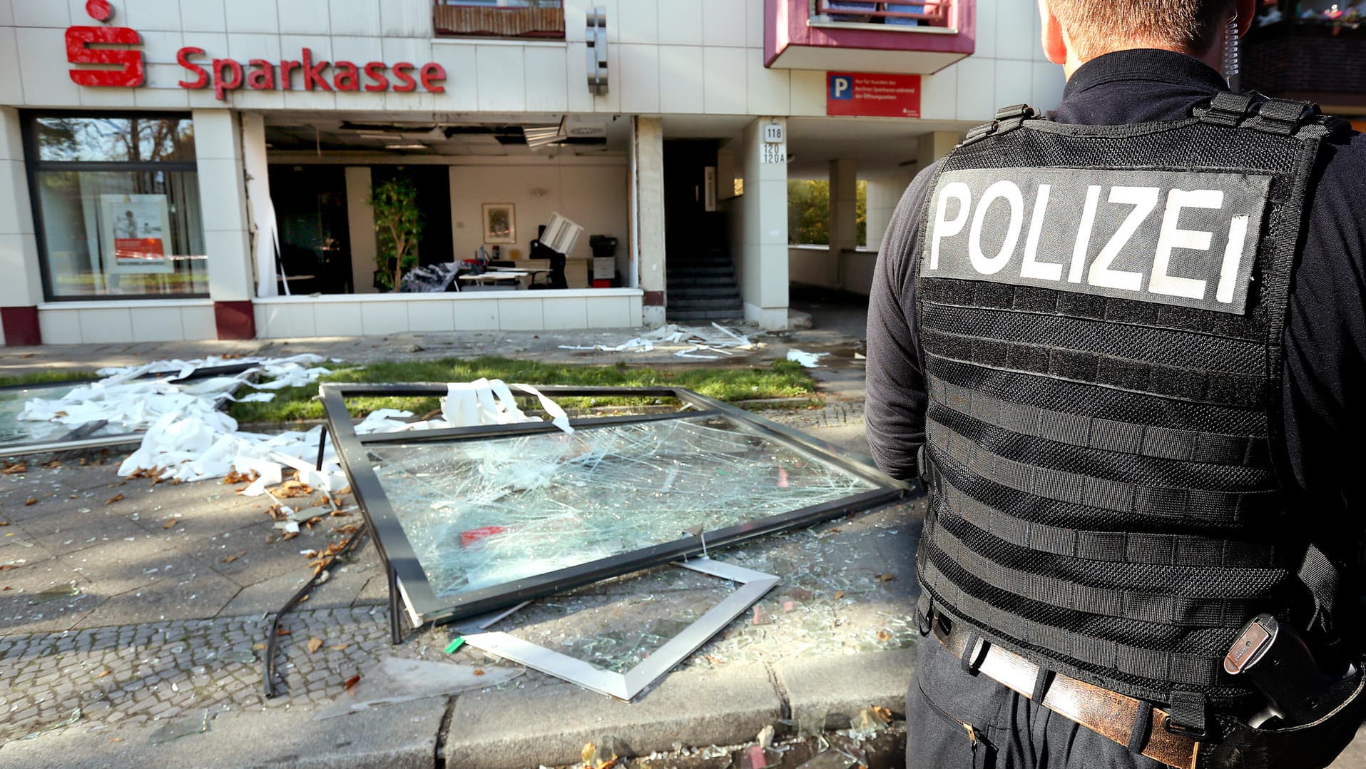 Ein Polizeibeamter sichert das Umfeld vor einer Sparkassenfiliale in Berlin. Unbekannte hatten in den frühen Morgenstunden in der Filiale am Mariendorfer Damm eine Explosion ausgelöst und Schließfächer ausgeräumt. Dieser Einbruch wird Clan-Mitgliedern zugerechnet.