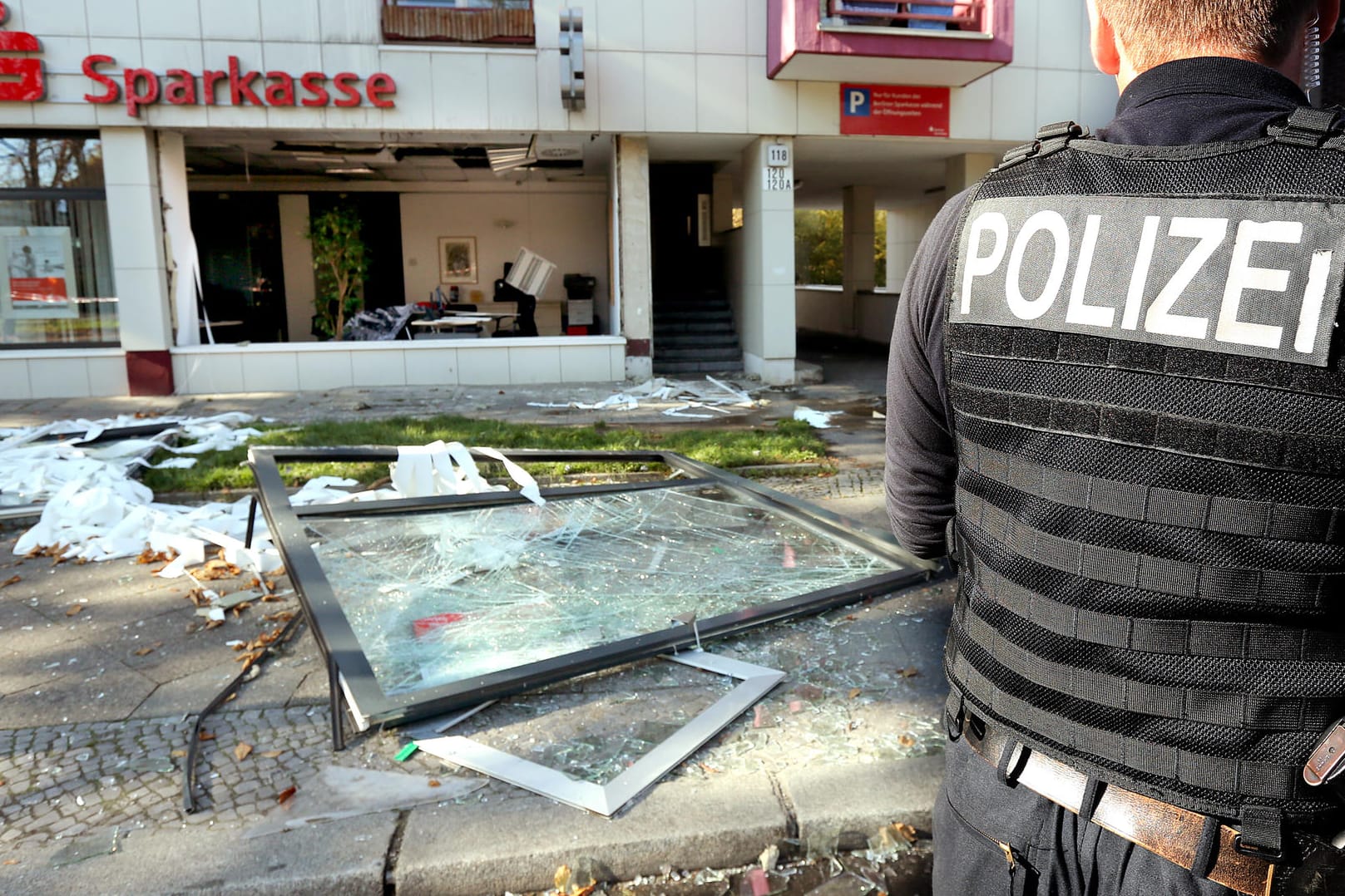 Ein Polizeibeamter sichert das Umfeld vor einer Sparkassenfiliale in Berlin. Unbekannte hatten in den frühen Morgenstunden in der Filiale am Mariendorfer Damm eine Explosion ausgelöst und Schließfächer ausgeräumt. Dieser Einbruch wird Clan-Mitgliedern zugerechnet.