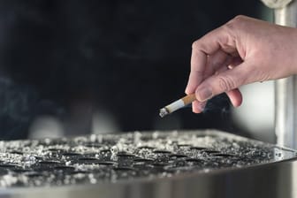 EIne Hand mit einer Zigaretten über einem Aschenbecher: Nächstes Jahr soll das Minderalter bereits auf 30 Jahre erhöht werden – und bis 2014 auf 100 Jahre steigen. (Symbolbild)