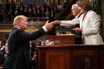 Donald Trump gibt vor seiner Rede zur Lage der Nation vor dem Kongress im Kapitol der Demokratin Nancy Pelosi, Vorsitzende des Abgeordnetenhauses, die Hand. Im Hintergrund steht Mike Pence, Vizepräsident der USA.