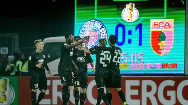 Augsburgs Spieler feiern den Treffer zum 1:0 gegen Holstein Kiel.