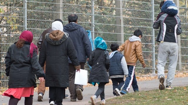 Flüchtlinge gehen über das Gelände der Erstaufnahmestelle in Suhl.