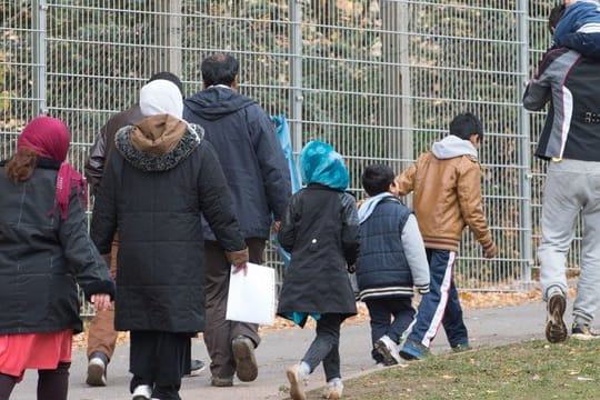 Flüchtlinge gehen über das Gelände der Erstaufnahmestelle in Suhl.
