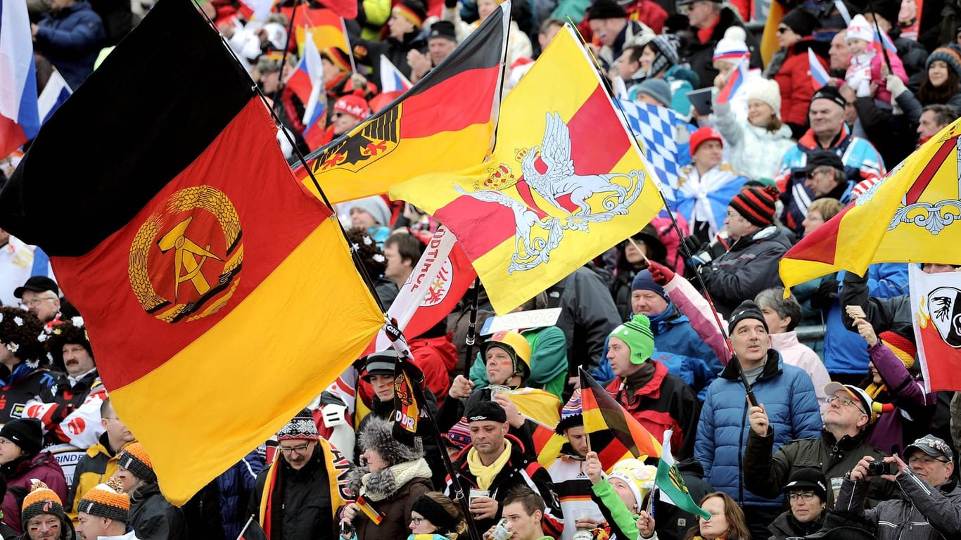 DDR-Flagge im Publikum (Symbolbild): Diese Aufnahme stammt vom Weltcup in Antholz (Italien) vom 19. Januar 2014.