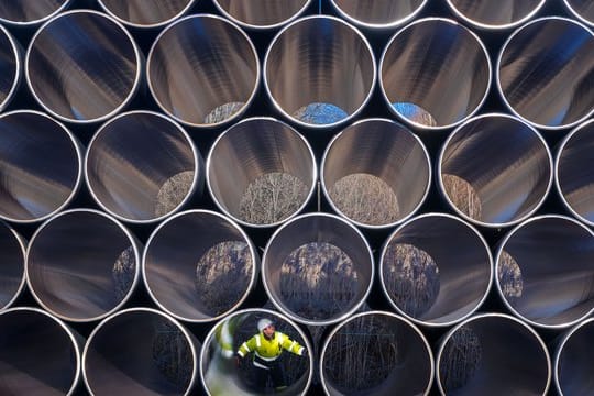 Ein Mitarbeiter prüft tonnenschwere Rohre für die zukünftige Ostsee-Erdgastrasse Nord Stream 2 auf einem Lagerplatz im Hafen vom Mukran auf Rügen.