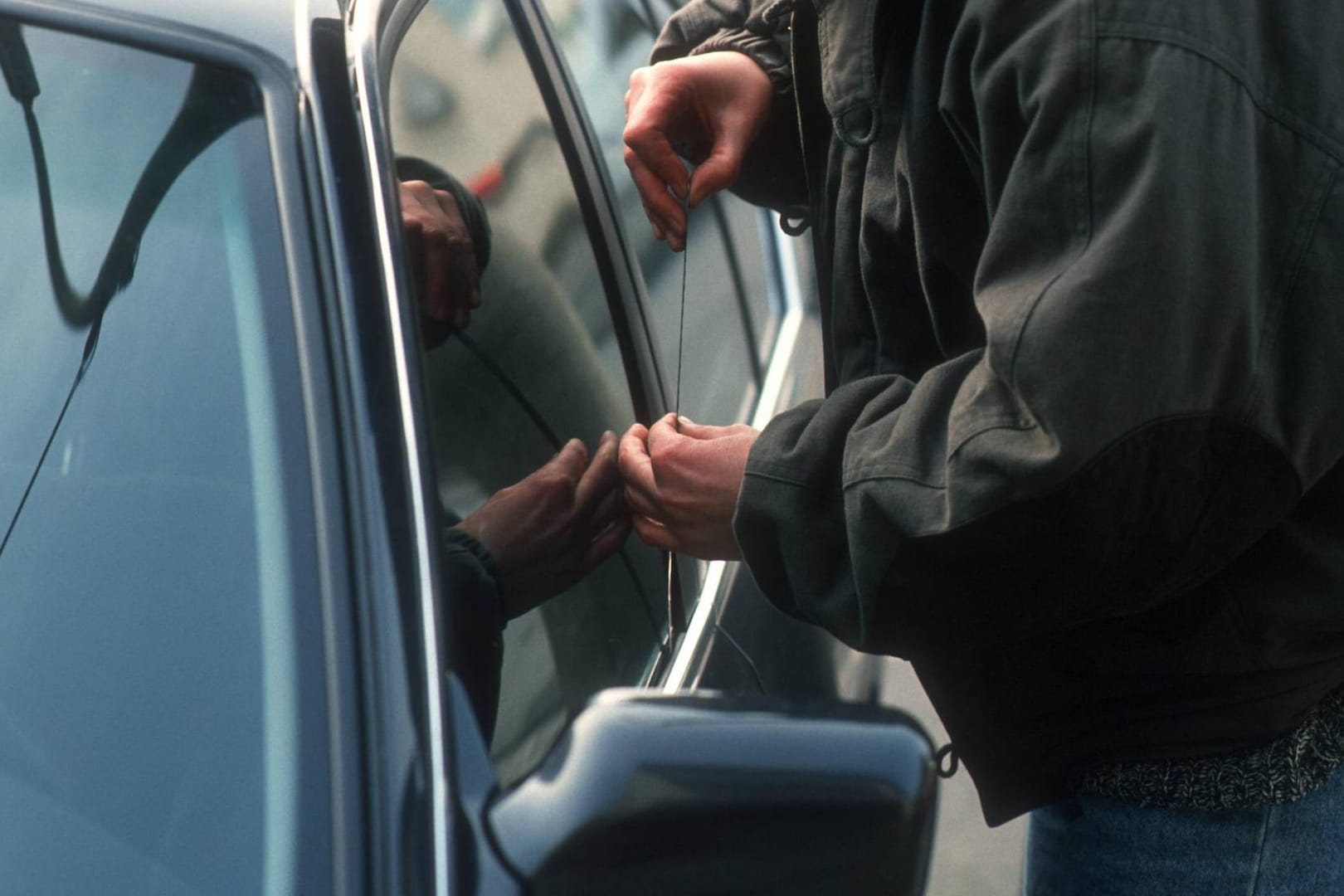 Ein Dieb knackt ein Auto (Symbolbild): Die Beamten konnten den Täter nur mit Mühe aus seinem Schlaf wecken.