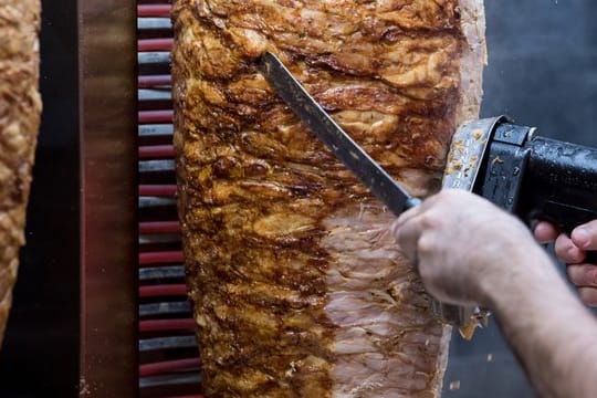 Dönerspieße drehen sich in einem Imbiss.