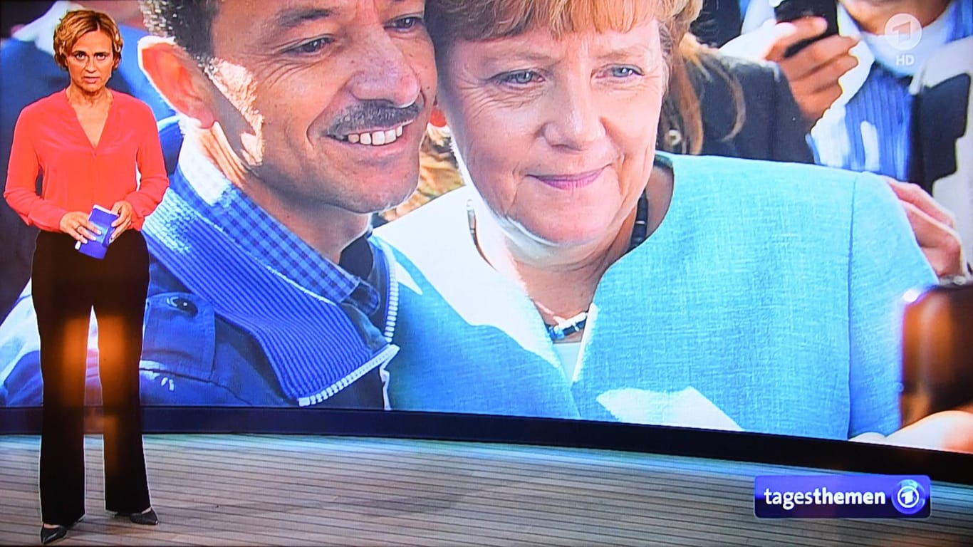 Die Tagesthemen zeigen ein Selfie von Merkel und einem Flüchtling: Dieses Foto wurde zum Symbolbild für Merkels angeblich ultraliberale Flüchtlingspolitik.