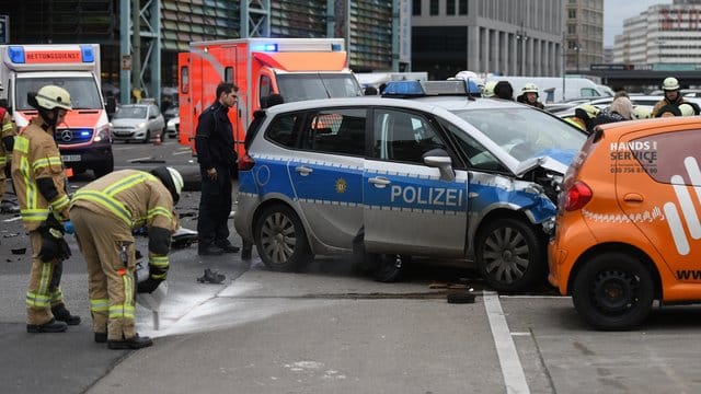 Ein Polizist und Feuerwehrmänner am Unfallort in Berlin.