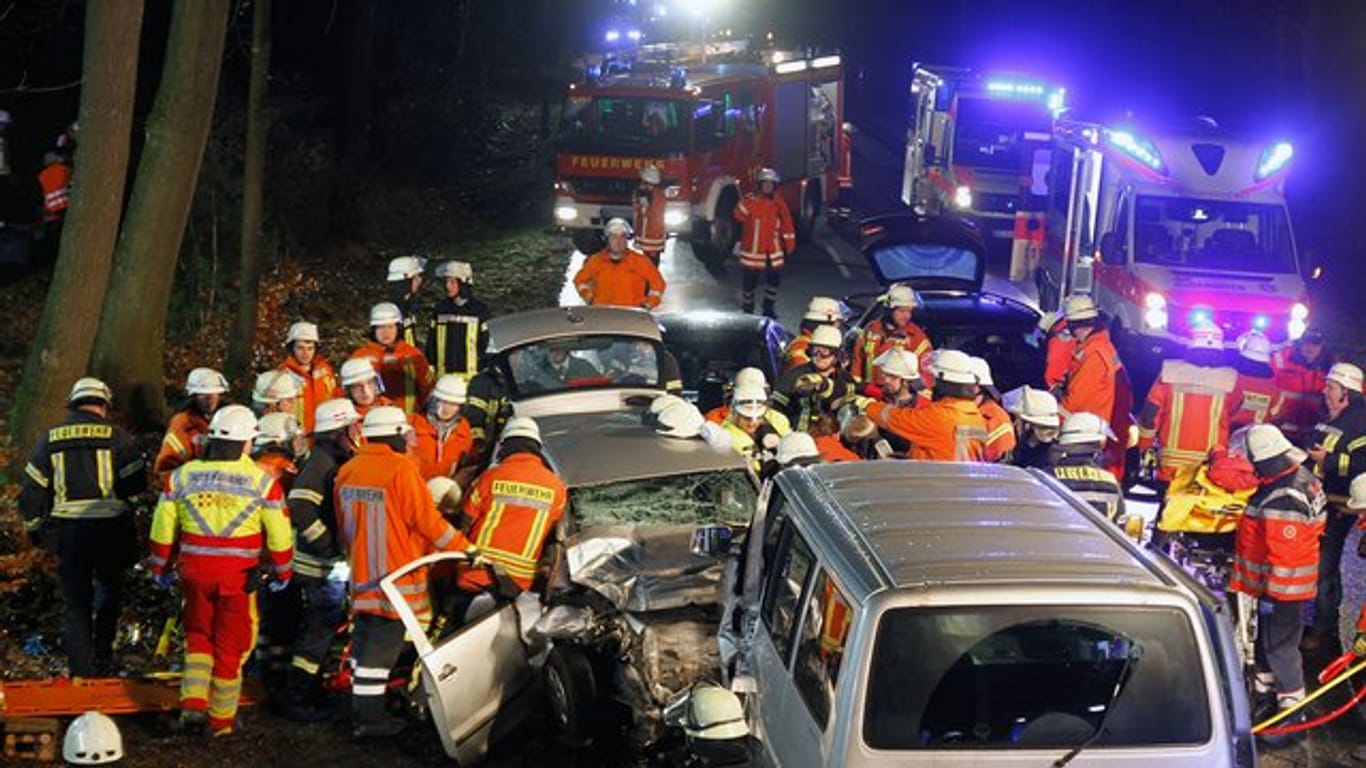 Rettungskräfte stehen neben dem Unfallwagen: Ein Überholmanöver kostet zwei Menschen das Leben. (Symbolbild)