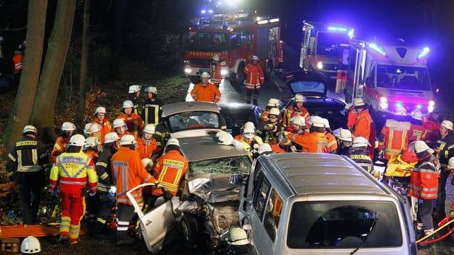 Rettungskräfte stehen neben dem Unfallwagen: Ein Überholmanöver kostet zwei Menschen das Leben. (Symbolbild)