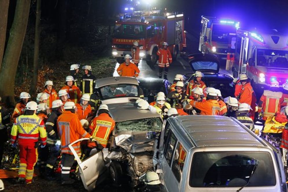 Rettungskräfte stehen neben dem Unfallwagen: Ein Überholmanöver kostet zwei Menschen das Leben. (Symbolbild)