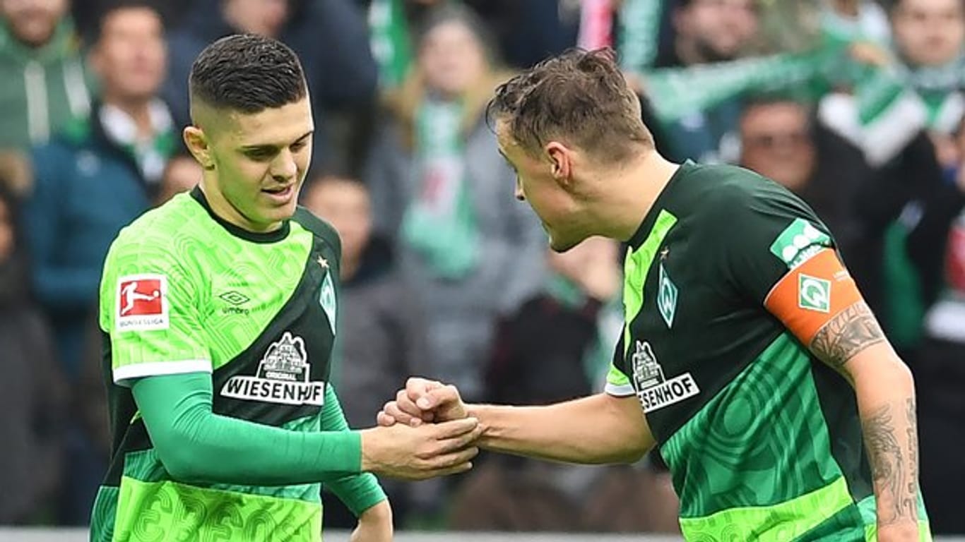 Werder Bremens Max Kruse (r) gratuliert Milot Rashica zu seinem Tor zum 3:0.