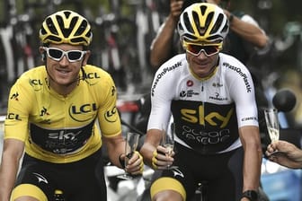 Geraint Thomas (l) fährt im Gelben Trikot des Gesamtführenden auf der letzten Etappe der Tour de France 2018 neben Chris Froome.