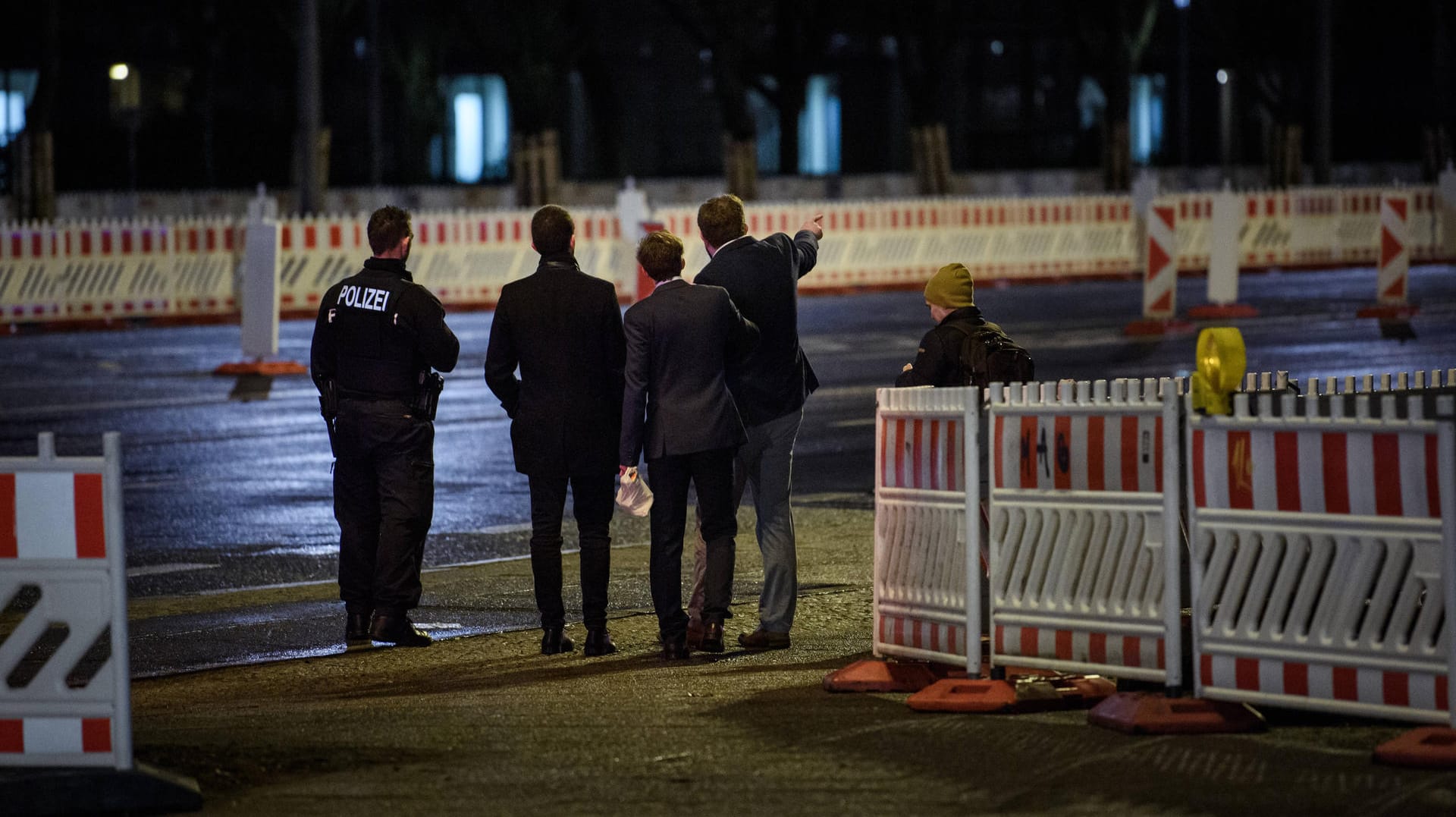 Mitglieder der Jugendorganisation der AfD stehen mit einem Polizistenvor dem Kino International: Einer der Verletzten beschuldigte die Antifa, hinter dem Angriff zu stehen.