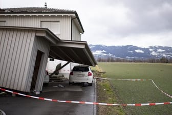 Das Dach eines beschädigten Hauses ragt nach Sturm "Uwe" auf ein davor geparktes Auto.