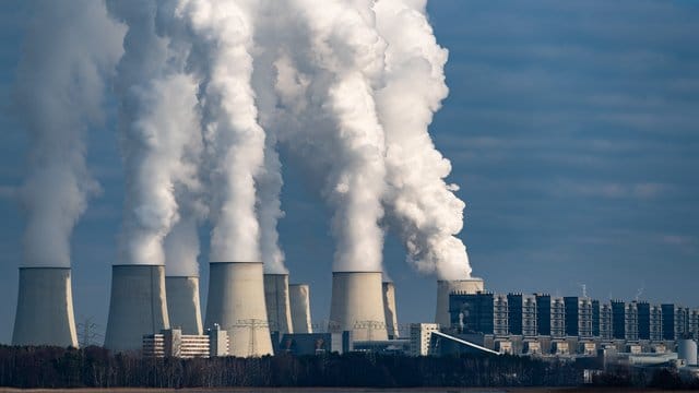 Wasserdampf steigt aus den Kühltürmen eines Braunkohlekraftwerks.