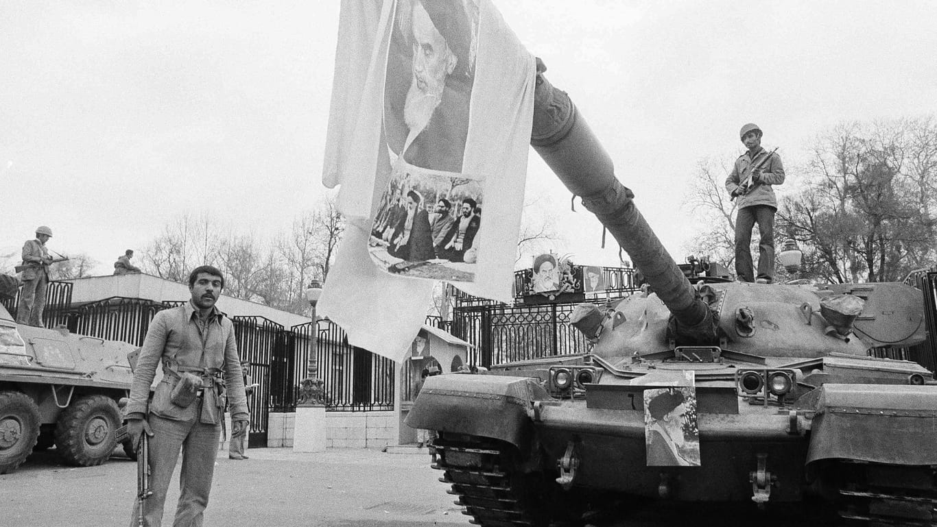 1979: Ein Bild von Ajatollah Ruhollah Chomeini am Kanonenrohr eines Panzers vor dem Niavaran-Palast. Am 11. Februar 1979 war im Iran das Ende der Monarchie verkündet worden.