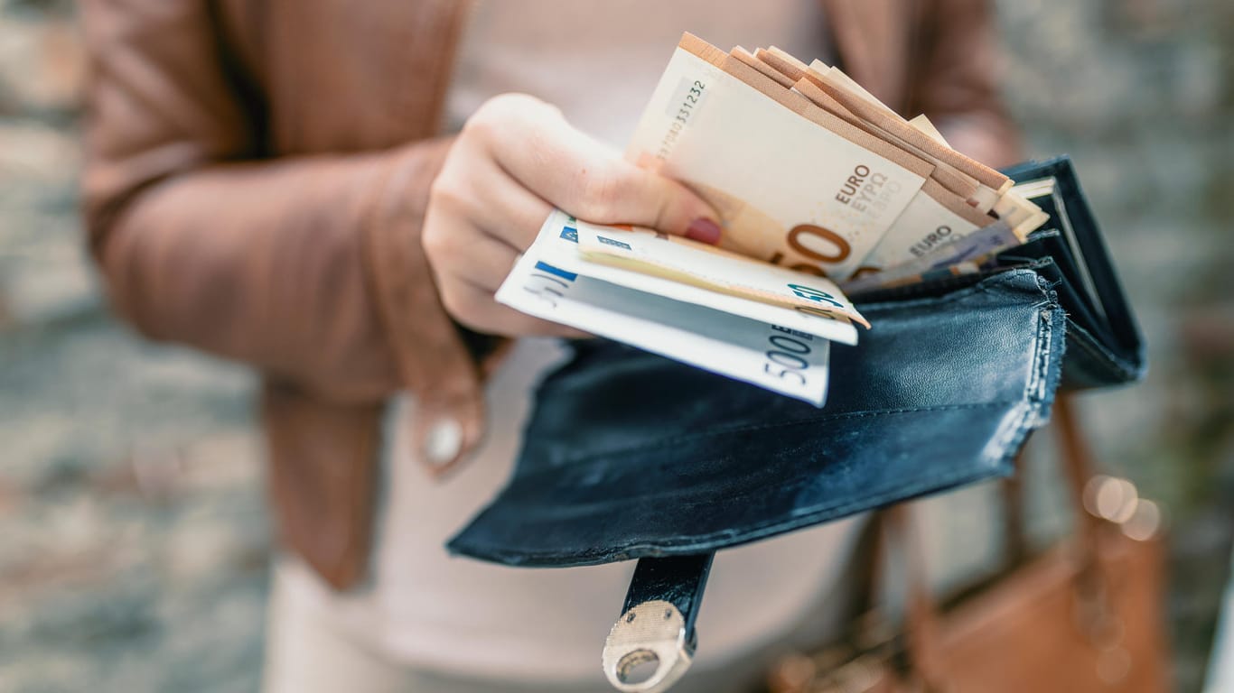 Eine Frau hält ein Portemonnaie mit Geldscheinen in den Händen: Das Projekt "Mein Grundeinkommen" verlost regelmäßig 12.000 Euro jährliches Grundeinkommen.