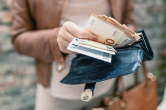 Eine Frau hält ein Portemonnaie mit Geldscheinen in den Händen: Das Projekt "Mein Grundeinkommen" verlost regelmäßig 12.000 Euro jährliches Grundeinkommen.