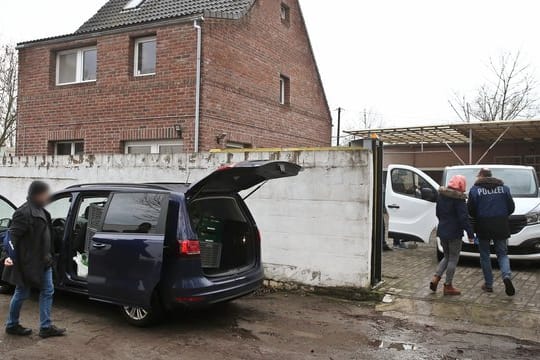 Polizeibeamte stehen vor einem Haus in Neuss.