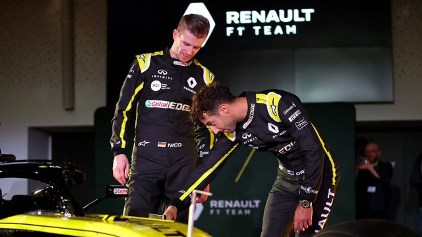 Nico Hülkenberg (l) und Daniel Ricciardo schauen sich den neuen Renault-Renner ganz genau an.