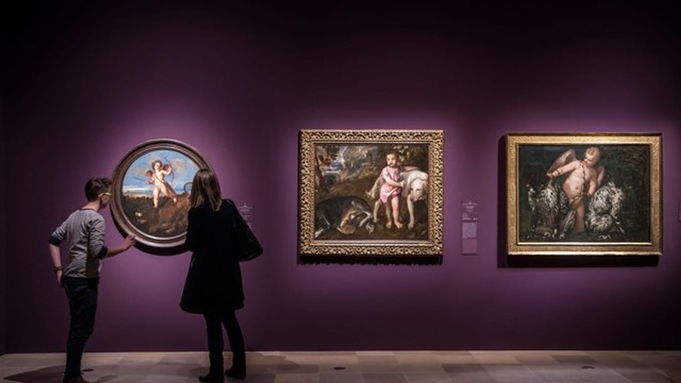 Eine Frau und ein junger Mann stehen vor dem Tizian-Werk "Der Triumph der Liebe" in der Ausstellung "Tizian und die Renaissance in Venedig" im Städel.