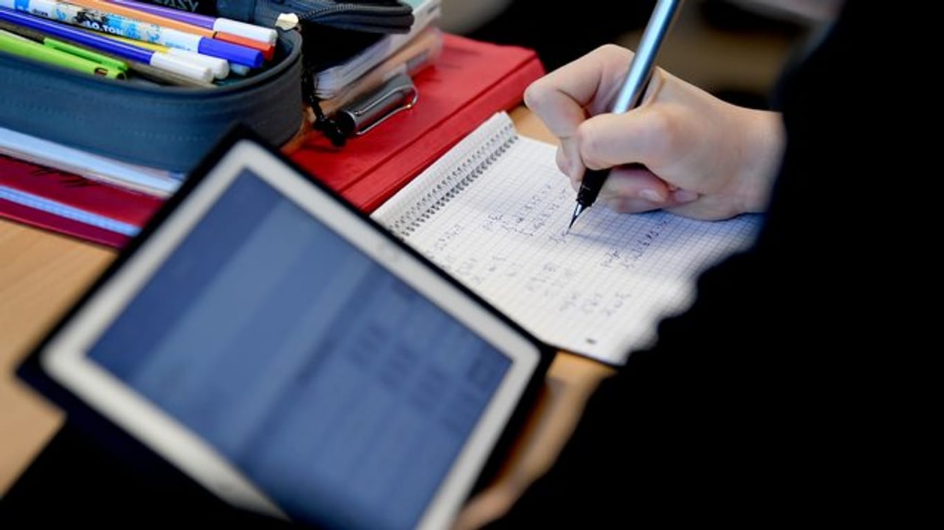 Komplett ausgestattet: Ein Schüler mit Tablet, Stift und Papier im Matheunterricht.