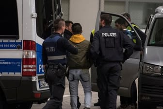Polizisten bringen einen jungen Mann aus Afghanistan zur Abschiebung zum Frankfurter Flughafen.