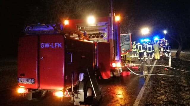 Feuerwehr und Rettungskräfte an der Unfallstelle auf einer Landstraße bei Köthen.