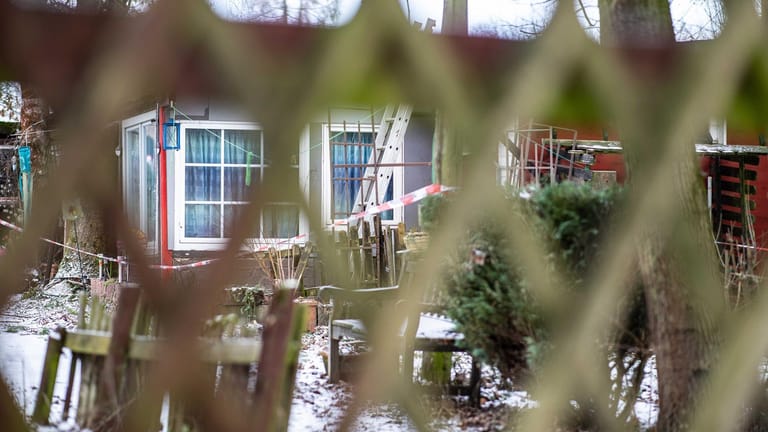 Blick durch einen Zaun auf ein Gebäude auf dem Campingplatz Eichwald, das mit einem Polizeiabsperrband versehen ist.