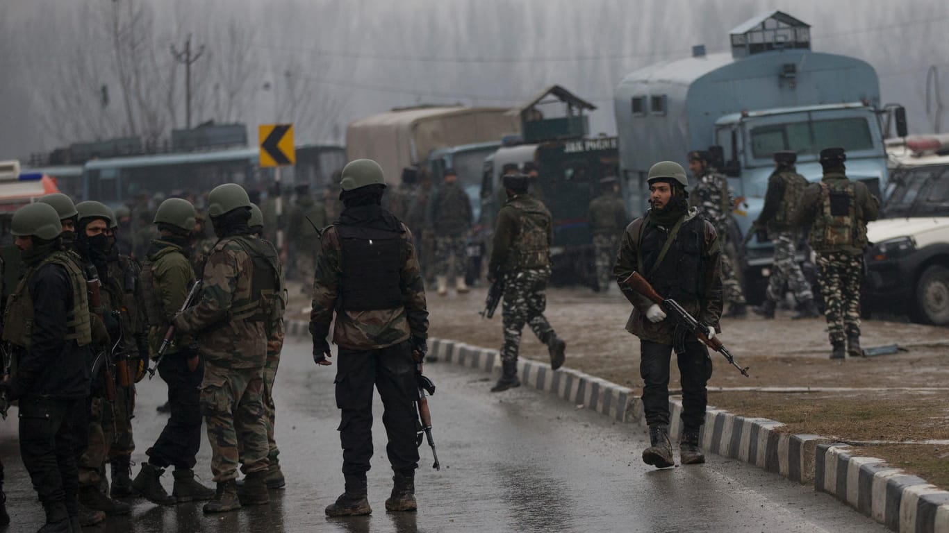 Soldaten der indischen Armee stehen in der Nähe eines Anschlagsortes auf der Straße: Bei einem Bombenanschlag im indischen Teil Kaschmirs sind mindestens 18 Sicherheitskräfte ums Leben gekommen.