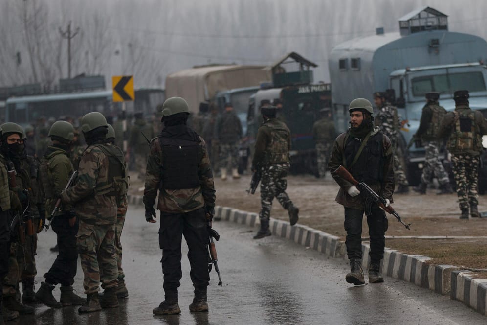 Soldaten der indischen Armee stehen in der Nähe eines Anschlagsortes auf der Straße: Bei einem Bombenanschlag im indischen Teil Kaschmirs sind mindestens 18 Sicherheitskräfte ums Leben gekommen.