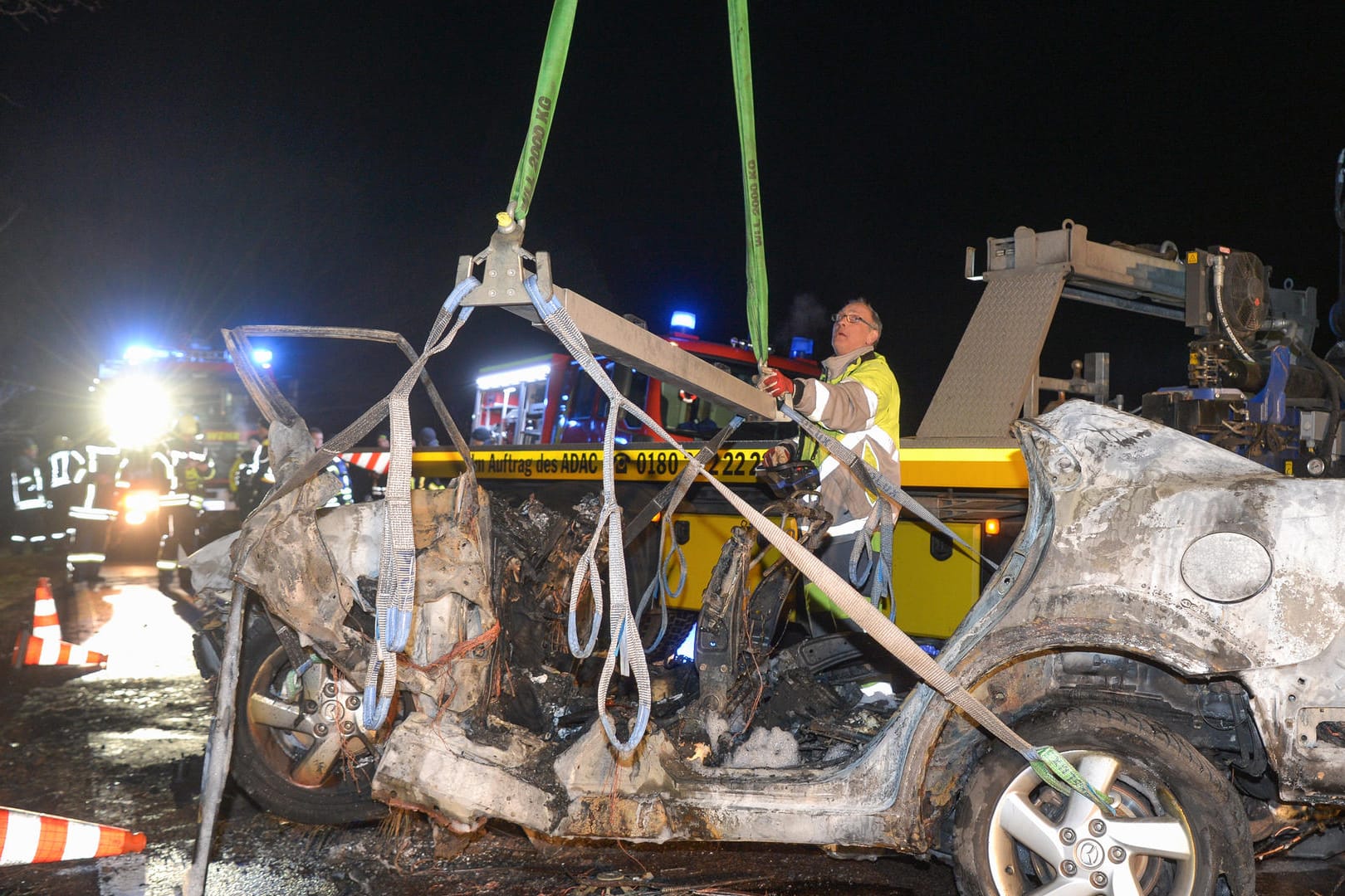 Auf einer Landstraße wird ein ausgebranntes Auto von einem Abschleppunternehmen aufgeladen: Bei dem Autounfall nahe Köthen sind drei Menschen, darunter ein Kind, verbrannt.