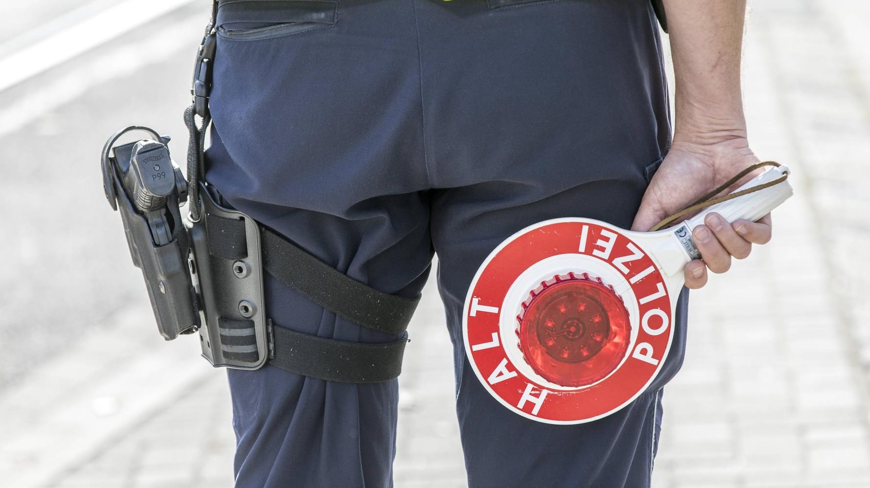 Polizist mit Anhaltekelle bei einer Verkehrskontrolle: Der Frau wurde ihr Führerschein abgenommen. Polizist mit Anhaltekelle bei einer Verkehrskontrolle: Der Frau wurde ihr Führerschein abgenommen.