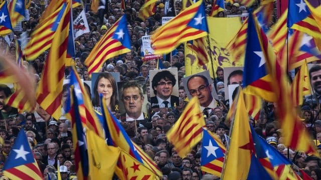Demonstranten tragen bei der Massenkundgebung in Barcelona Fahnen und Bilder ehemaliger katalanischer Regierungmitglieder. Demonstranten tragen bei der Massenkundgebung in Barcelona Fahnen und Bilder ehemaliger katalanischer Regierungmitglieder.