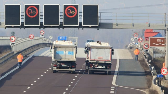 Vier LKW fahren über die Elbbrücke der Autobahn 2 bei Lostau.