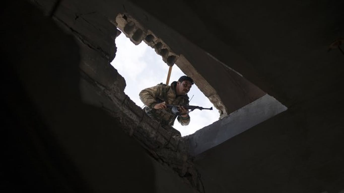 Ein Kämpfer der von den USA unterstützten Syrischen Demokratischen Kräfte durchsucht ein Gebäude in Baghus.